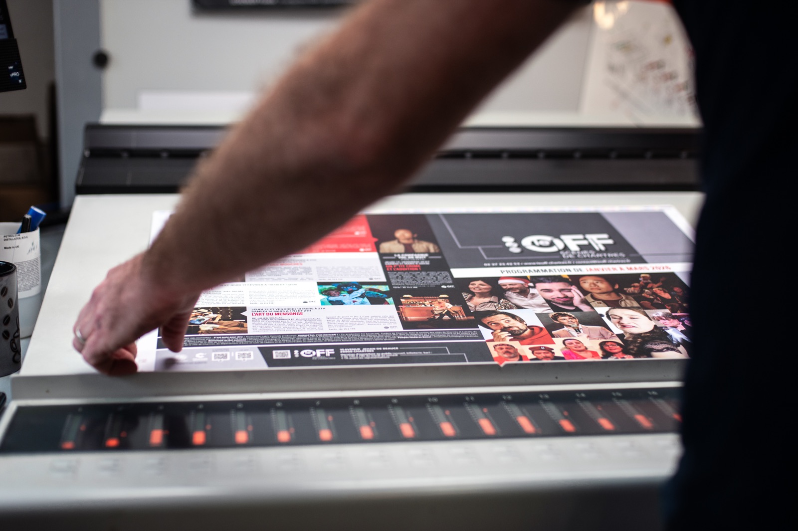 Operator checking a printed sheet at the press console